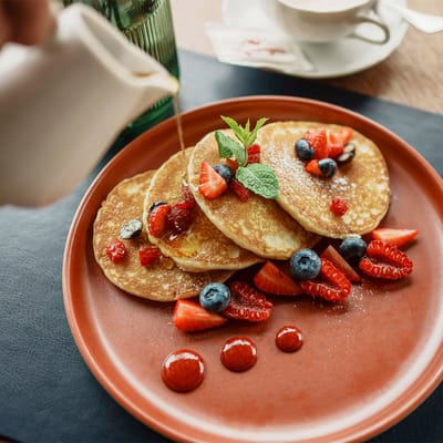 Dettaglio colazione con pancake e frutta fresca